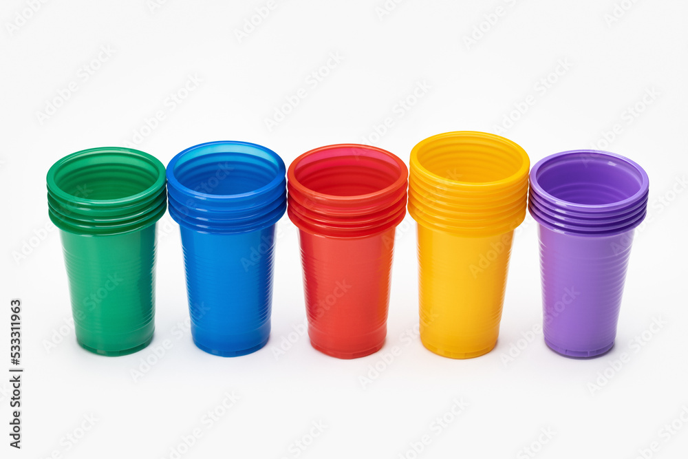 Set in a row of multi-colored disposable cups for drinks, studio shot. Plastic recycling. Set in a row of multi-colored disposable cups for drinks, studio shot. Plastic recycling.