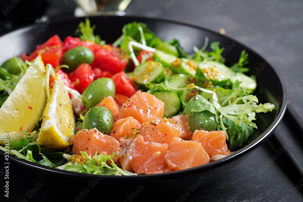 Ketogenic, keto or paleo diet lunch bowl with salted salmon fish, lemon, cucumber, olives, tomatoes, green lettuce salad and honey mustard dressing. Healthy food trend. Ketogenic, keto or paleo diet lunch bowl with salted salmon fish, lemon, cucumber, olives, tomatoes, green lettuce salad and honey mustard dressing. Healthy food trend.