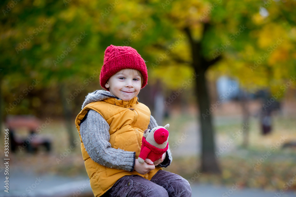 Happy child, playing with in autumn park on a sunny day, foliage and leaves all around him Happy child, playing with in autumn park on a sunny day, foliage and leaves all around him
