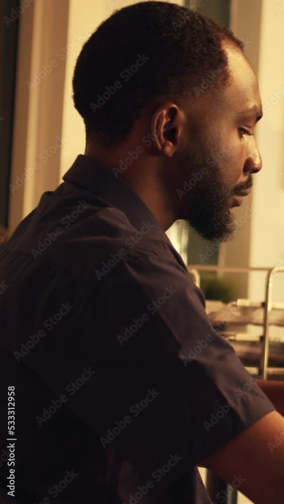 Vertical video: African american worker analyzing company data on computer to plan research and presentation. Working with financial project and shares to create corporate report at sunset. Handheld Vertical video: African american worker analyzing company data on computer to plan research and presentation. Working with financial project and shares to create corporate report at sunset. Handheld