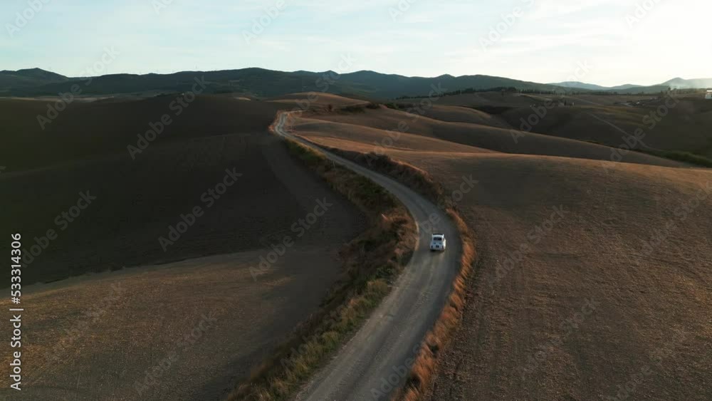 Aerial view of a little Italian vehicle driving a countryside road. Florence, Tuscany, Italy.