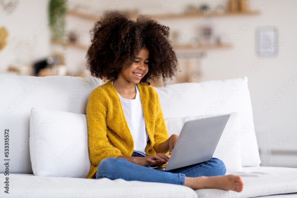 Happy african american child using laptop at home Happy african american child using laptop at home