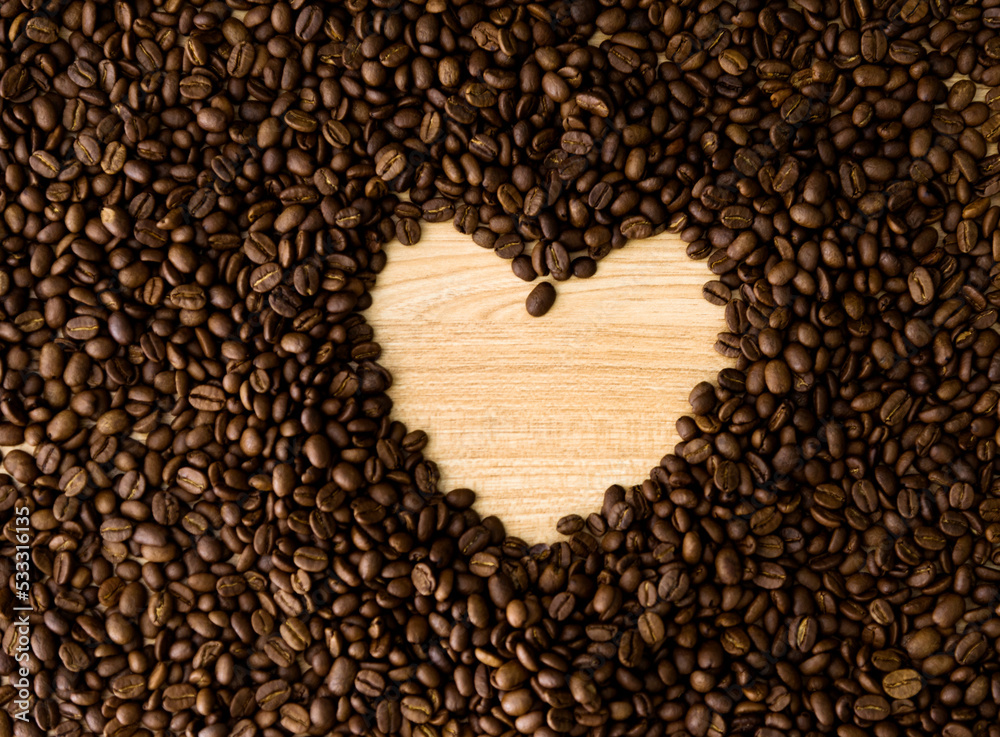 Heart shape frame from coffee beans on wooden table Heart shape frame from coffee beans on wooden table