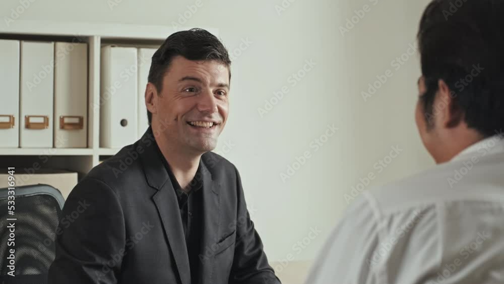 Medium shot of professional hr manager interviewing candidate while sitting in front of each other at office desk Medium shot of professional hr manager interviewing candidate while sitting in front of each other at office desk
