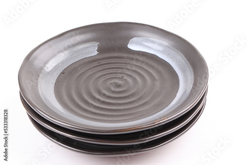 Empty black ceramic plate isolated on white