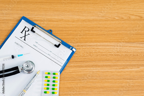 Medical clipboard with stethoscope and pills on desk © xy