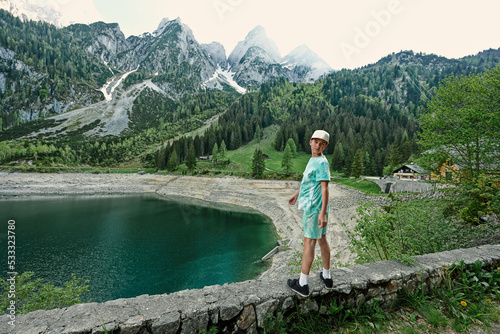 Boy stand against lake and mountains at Vorderer Gosausee, Gosau, Upper Austria.