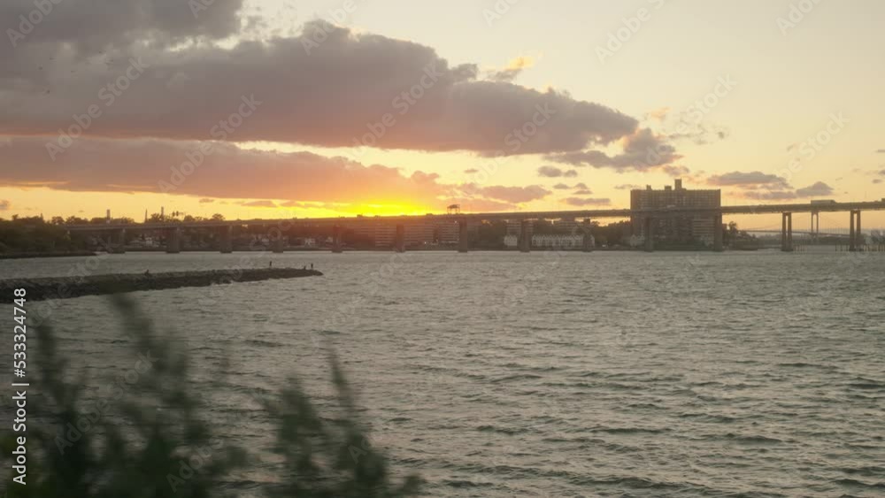 sunset over a bridge showing the water and sky Turing golden hour with the city in the background. sunset over a bridge showing the water and sky Turing golden hour with the city in the background.