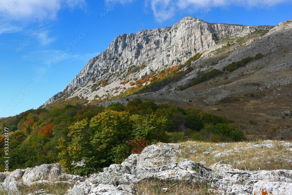Picturesque mountain rocky peak and surrounding mountain landscape on a sunny autumn day. The peak 'Eklizi-Burun' is one of the highest peaks of the Crimean mountains.