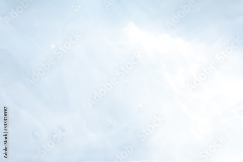 Blurred ripple water texture on white background. Shadow of water on sunlight. Mockup for product, spa or travel background. Marble water surface as wallpaper background