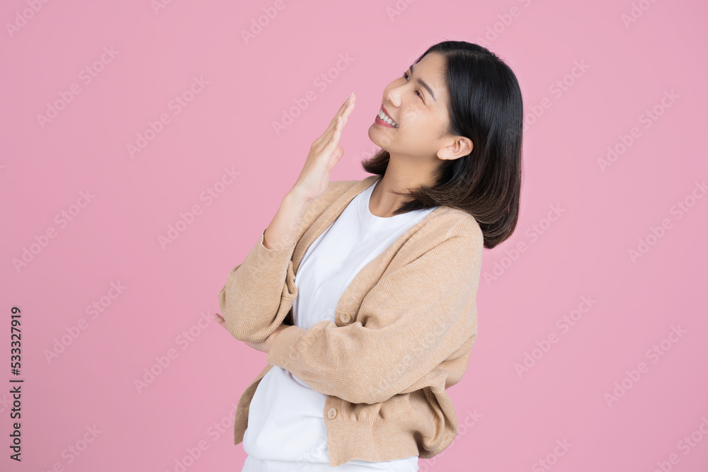 Asian girl wearing a cream colored casual dress, she is surprised standing isolated on a pink background wall. Asian girl wearing a cream colored casual dress, she is surprised standing isolated on a pink background wall.