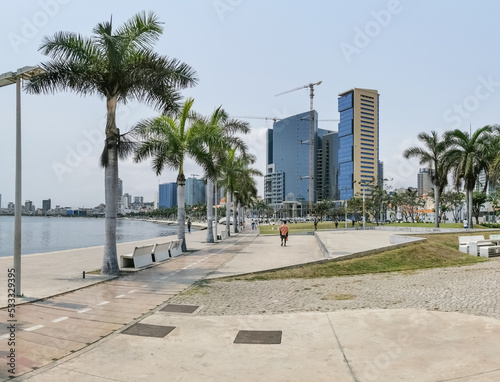 View at the Luanda bay and Luanda marginal, pedestrian pathway with tropical palm trees, downtown lifestyle, Cabo Island, Port of Luanda and modern skyscrapers