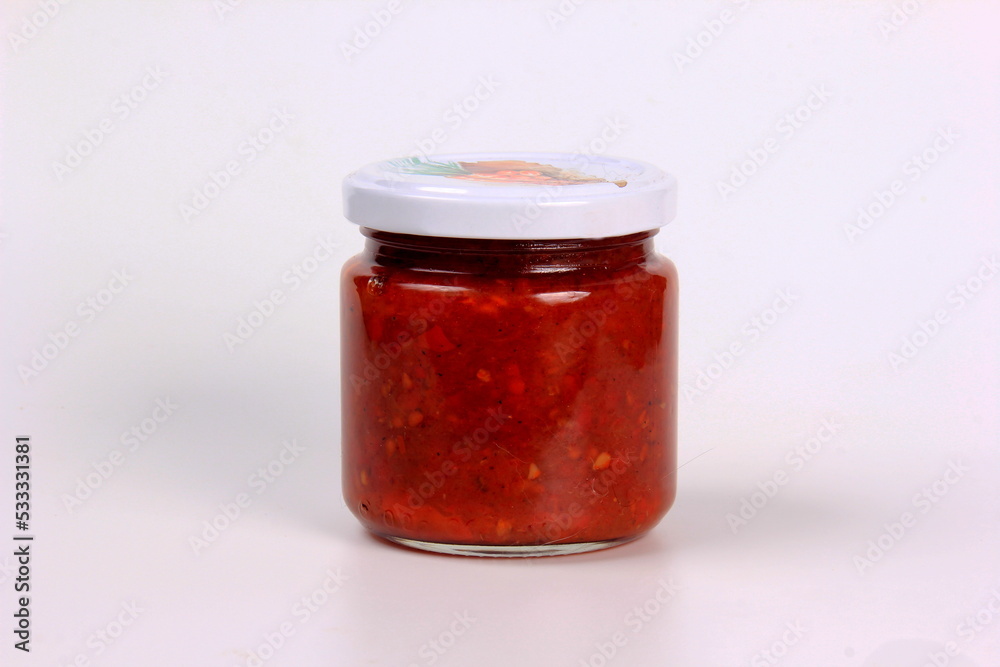 glass jar with boiled red tomato sauce on a white background glass jar with boiled red tomato sauce on a white background