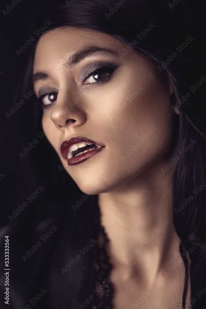 portrait of a woman wearing vampire fangs, with her mouth open and lookingr right at the camera portrait of a woman wearing vampire fangs, with her mouth open and lookingr right at the camera