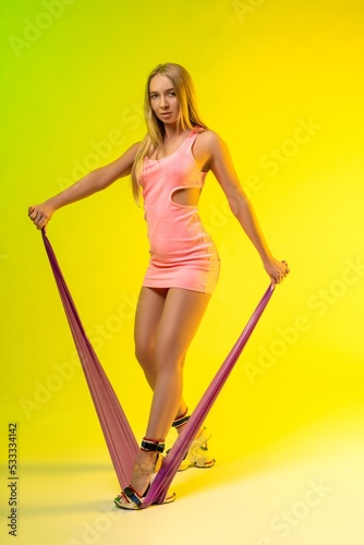 Slim woman exercising with elastic band