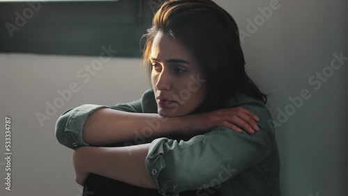 Video of depressed woman sitting on the coach at home.