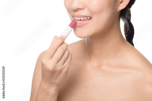 Portrait young asian woman looking mirror applying makeup lipstick at room
