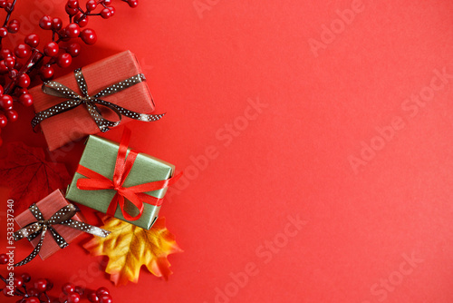 Christmas background with gift boxes and decorations on red background.