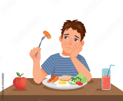 Young man has no appetite to eat food sitting in front of breakfast at table 
 photo