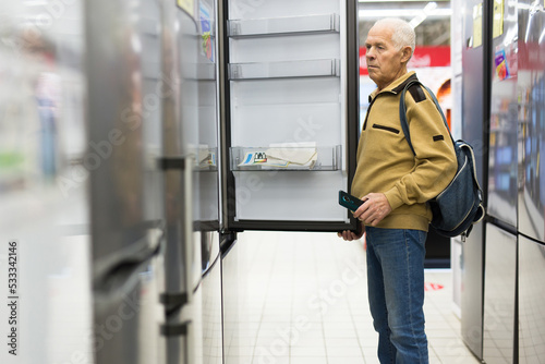 senor man pensioner buying fridge in showroom of electrical appliance store © caftor