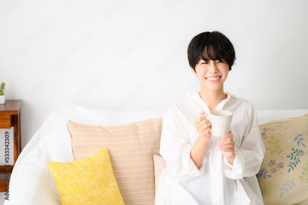 Woman relaxing in her room drinking coffee or other beverages Woman relaxing in her room drinking coffee or other beverages