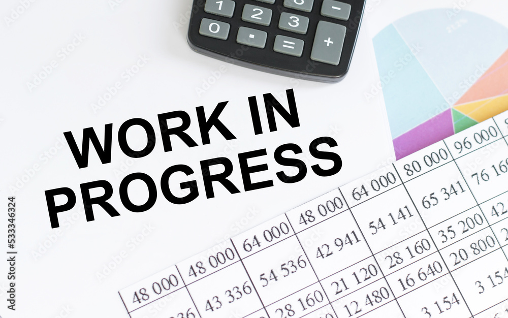 WORK IN PROGRESS text on a notebook on an office desk, a business concept WORK IN PROGRESS text on a notebook on an office desk, a business concept