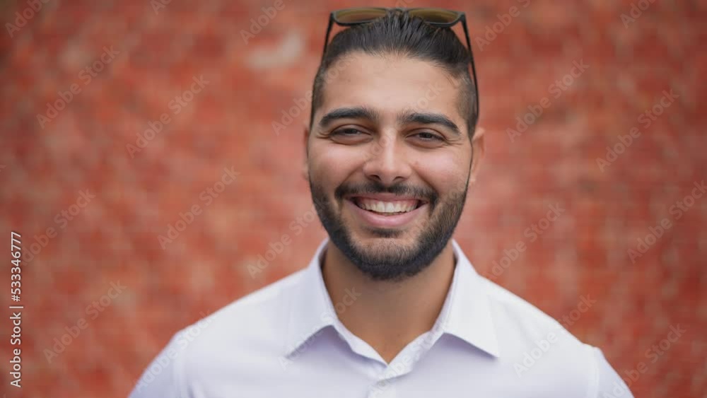 Portrait of a handsome young man or businessman in a white shirt turns and looks at the camera and smiles. Portrait of a handsome young man or businessman in a white shirt turns and looks at the camera and smiles.