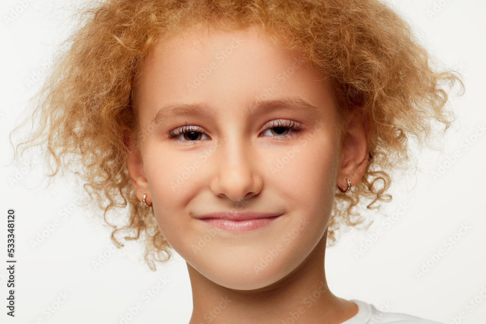 Closeup of smiling little girl, kid in white t-shirt isolated over white studio background. Concept of children emotions Closeup of smiling little girl, kid in white t-shirt isolated over white studio background. Concept of children emotions