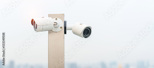 Modern CCTV camera against city and sky background. surveillance  video record and monitoring concept