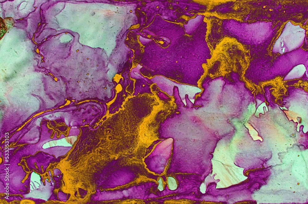 Purple and pink areas filled with golden dust on Alcohol ink fluid abstract texture fluid art with gold glitter and liquid.