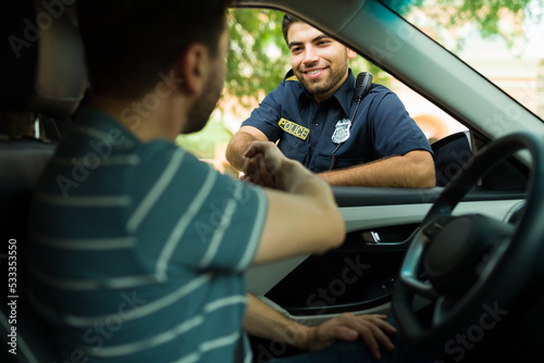 Fototapeta Cheerful police agent talking with a driver