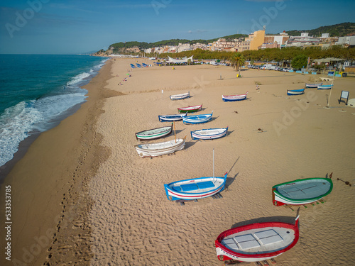 Aerial view of Pineda de Mar beach over fishermen boats beach without people turquoise blue sea photo