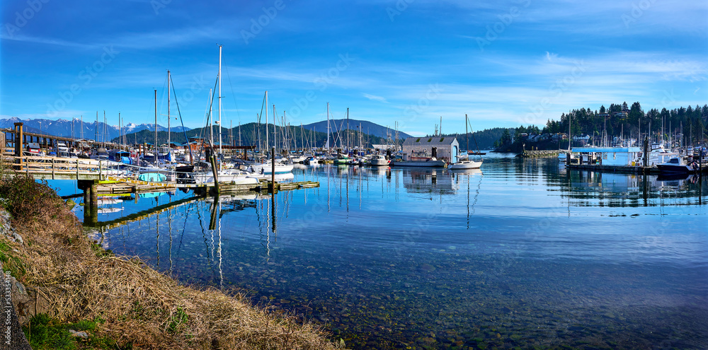 Gibsons Harbour. Yachts, boats at the piers against the backdrop of mountains in sunny weather. Gibsons, Sunshine Coast, BC, Canada - obrazy, fototapety, plakaty 
