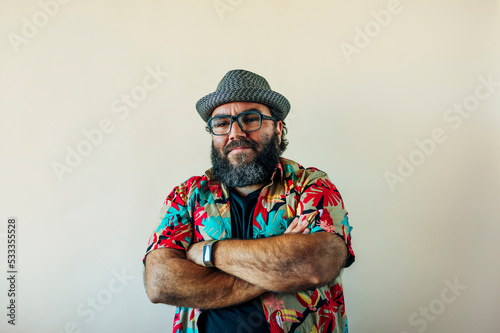 Fat man with beard and hat looking at camera.