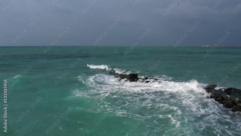 Drone flyby over a rock breakwater in the sea Drone flyby over a rock breakwater in the sea