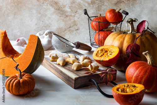 Uncooked homemade pumpkin gnocchi on wooden board. photo