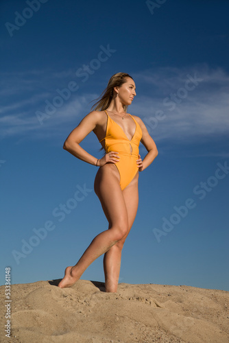 sports woman in a swimsuit on the sand