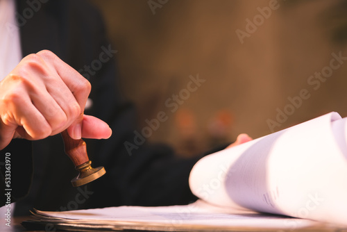 close-up of person stamping documents to approve agreements,