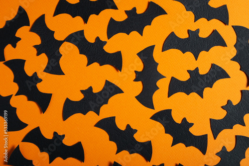 Orange background with black bats. Concept for Halloween