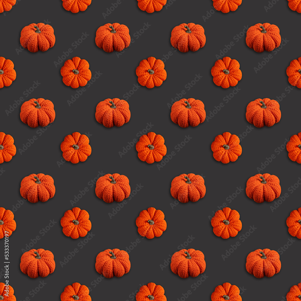 Seamless pattern depicting a knitted pumpkin on a dark gray background, Halloween concept Seamless pattern depicting a knitted pumpkin on a dark gray background, Halloween concept