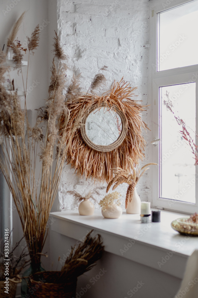 Boho room. Minimalistic eco friendly design details. Natural fabric materials. Cozy light pastel Scandinavian interior. Basket with pampas grasses. window sill and mirror decorated with dried flowers Boho room. Minimalistic eco friendly design details. Natural fabric materials. Cozy light pastel Scandinavian interior. Basket with pampas grasses. window sill and mirror decorated with dried flowers