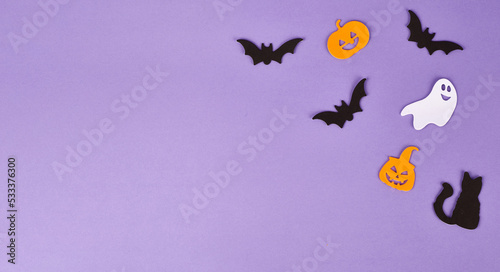 Halloween decorations  pumpkins  on violet background. Halloween party greeting card. Copy space. Flat lay  top view  overhead.