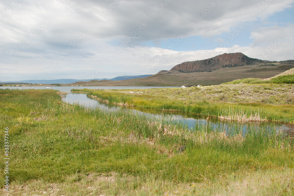 Fototapeta premium Marshy landscape with lake and mountains