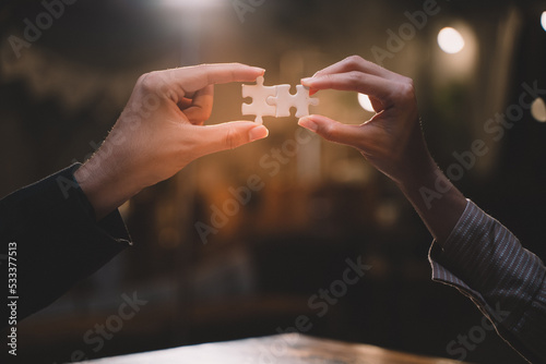 Close-up of business hands connecting jigsaw puzzle, success and goal achievement, the last jigsaw is the link of all the pieces. strategic planning or a solution for the management.