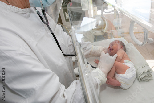 A doctor watches over a premature baby in the hospital.