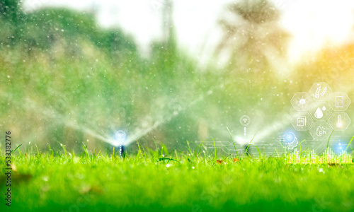 Automatic lawn sprinkler watering green grass and icon of smart farming concept. Smart agriculture with modern technology concept. Sustainable agriculture. Precision agriculture. Climate monitoring. © Artinun