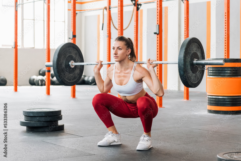 Sportswoman doing barbell back squat