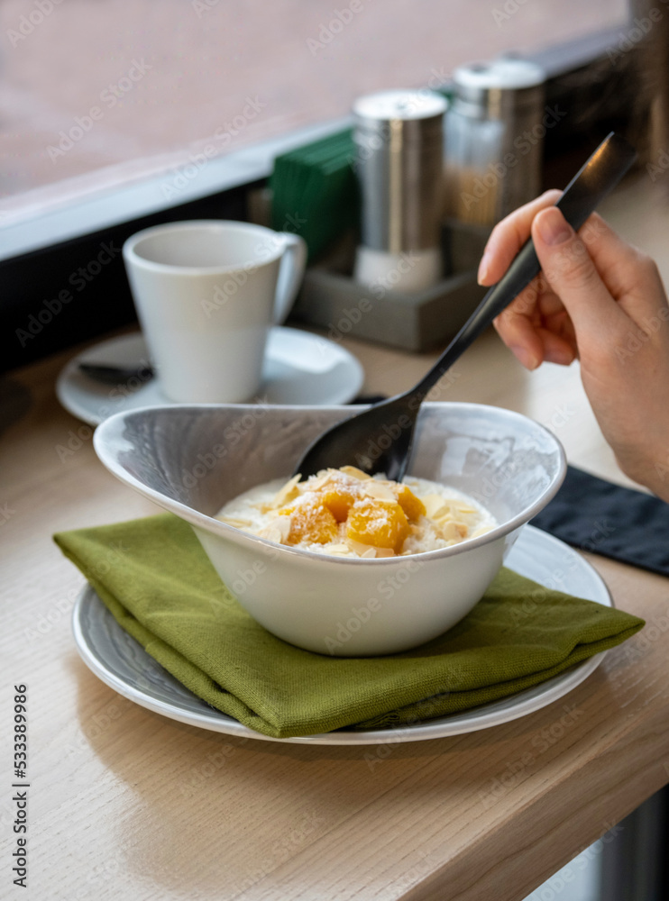 Breakfast served with oatmeal, yogurt and fruits. Delicious healthy breakfast. Breakfast at the restaurant. Oatmeal in a restaurant. Restaurant supply. Live.