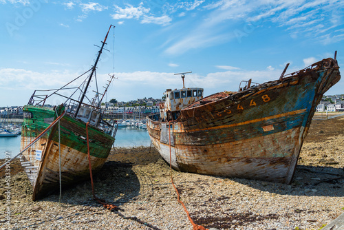 Two wrecked vessels moored at the marina of Camaret Sur Mer, Brittany, France. Text translation: 
