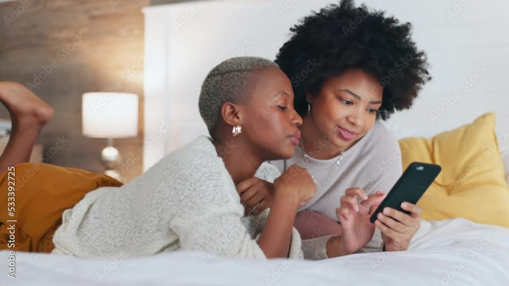 Black women, phone and bond while laughing in house bedroom and home interior and looking at internet dating app profile. Smile, happy or comic friends on mobile communication technology for fun game